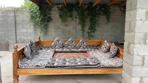 a wooden bed with pillows on top at Guest Home in Jalal-Abad