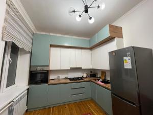 a kitchen with blue cabinets and a refrigerator at Guest Home in Jalal-Abad