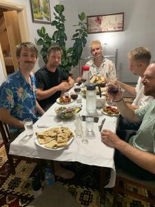a group of men sitting around a table eating food at Vila Bashllari in Zvarisht