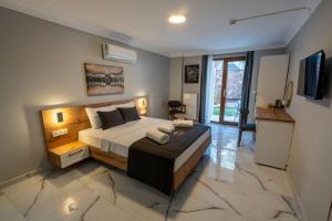 a bedroom with a large bed and a television at Rumet Cunda Otel in Ayvalık
