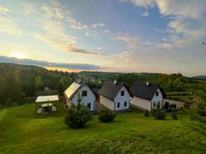 a group of houses on a green field at Bieszczadzki Bohater Domki 533-502-137 in Polańczyk