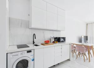 a white kitchen with a washing machine in it at BelMare Seaside Apartment by Solarento in Międzyzdroje