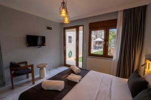 a bedroom with a bed with a chair and a window at Rumet Cunda Otel in Ayvalık +43 photos