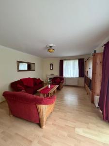 a living room with a red couch and a table at Ferienhaus Villa Deichfürst in Dorum-Neufeld