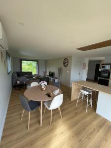 a kitchen and living room with a table and chairs at Mur des Horizons in Plouigneau