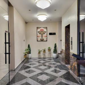 a lobby with potted plants and a painting on the wall at Hotel Meridian in Jagādhri