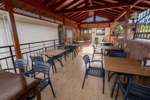 an empty restaurant with wooden tables and chairs at Rumet Cunda Otel in Ayvalık