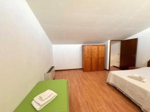 a room with a bed and a green bench at Agriturismo Nani in Altavilla Monferrato
