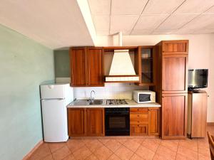 a kitchen with wooden cabinets and a white refrigerator at Agriturismo Nani in Altavilla Monferrato
