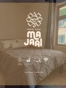 a bed with a mjad sign on the wall at Hotel Casa Majaal in Ixtapan de la Sal