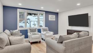 a living room with chairs and a flat screen tv at Motel Luzerne in Lake Luzerne