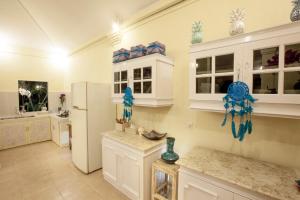 eine Küche mit weißen Schränken und einem Kühlschrank in der Unterkunft Villa Alam Biru Gardenia in Seminyak