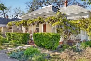 a white house with bushes in front of it at Whimsy On B- 1 block to downtown Ashland in Ashland
