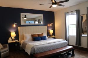 a bedroom with a bed with blue pillows and a ceiling fan at Eagle’s Landing Lodge in Custer