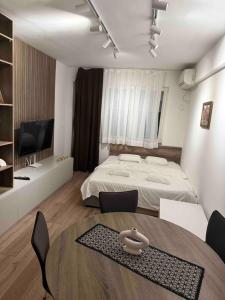 a bedroom with a bed and a table and chairs at NeWave Apartment 2 in Strumica