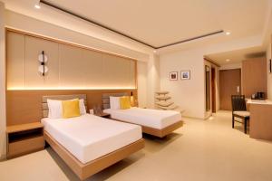 a hotel room with two beds and a desk at Regenta Place CG Road in Ahmedabad