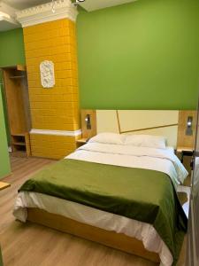 a bedroom with a bed with a green and yellow wall at Three Colour Rooms in Kutaisi +21 photos