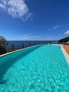 a swimming pool with the ocean in the background at Villa La Dolce Vista & Private hydro pool in Costa Paradiso