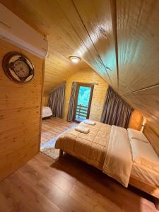 a bedroom with a large bed in a wooden room at Guri i Lekës Guesthouse in Shkodër