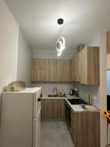 a kitchen with a white refrigerator and wooden cabinets at Laki in Donji Štoj