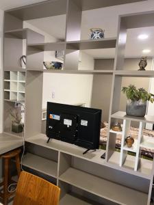 a living room with a tv on a shelf at Yerba Buena House in Yerba Buena