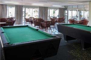 a room with a pool table and tables and chairs at Hermanus Oceanbay View in Hermanus