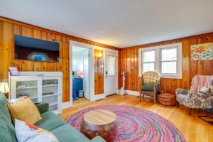 a living room with a couch and a tv at Blocks to Beach & Eats! Elk Rapids 'Cozy Cottage' in Elk Rapids