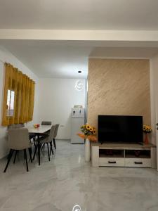 a living room with a tv and a table with chairs at Laki in Donji Štoj