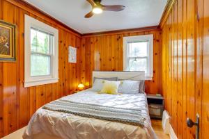 a bedroom with wood paneled walls and a bed at Blocks to Beach & Eats! Elk Rapids 'Cozy Cottage' in Elk Rapids