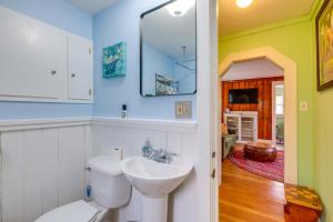 a bathroom with a sink and a toilet and a mirror at Blocks to Beach & Eats! Elk Rapids 'Cozy Cottage' in Elk Rapids +19 photos
