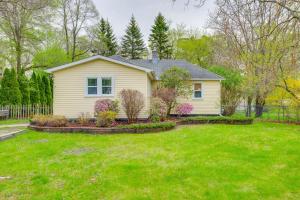 a yellow house with a yard with a yard at Blocks to Beach & Eats! Elk Rapids 'Cozy Cottage' in Elk Rapids
