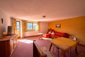 a living room with a red couch and a table at Ferienhof Almfrieden in Balderschwang