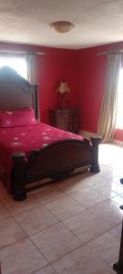 a bedroom with a bed with a red wall at Paradise treasure view in Montego Bay