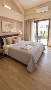 a bedroom with a large bed with two towels on it at Danny Arz Apartments in Iraklitsa
