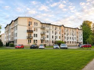 a large building with cars parked in a parking lot at Babite Quiet Apartment in Babīte