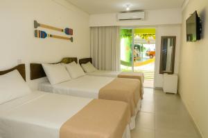 a hotel room with two beds and a balcony at Pousada Solar Dos Carneiros in Praia dos Carneiros +62 photos