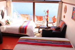 a bedroom with a bed and a view of the ocean at Uros Titicaca Aru Lodge in Puno +14 photos