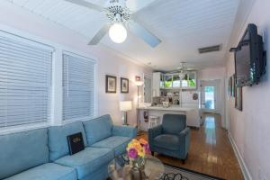 a living room with a blue couch and a table at KW41 Amelia House in Key West