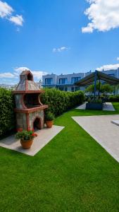 a garden with a brick oven in the grass at Danny Arz Apartments in Iraklitsa