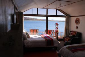 a bedroom with a bed and a view of the water at Uros Titicaca Aru Lodge in Puno