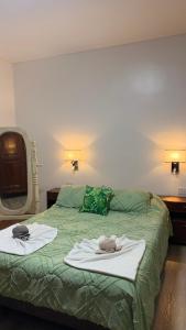 a bedroom with two towels on a green bed at Amoite hotel boutique in Nuestra Señora del Rosario de Caa Catí
