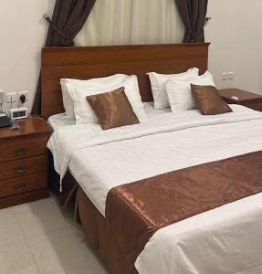 a hotel room with two beds and a night stand at شاطئ الأحلام الحديث للشقق المخدومة in Taif