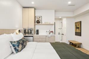 a bedroom with a large white bed and a kitchen at Casa Iglesia in Santa Barbara