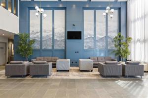 a lobby with a waiting room with chairs and windows at Sandman Hotel & Suites Calgary West in Calgary
