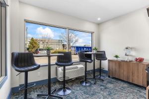 a room with three bar stools and a window at Sandman Hotel & Suites Calgary West in Calgary