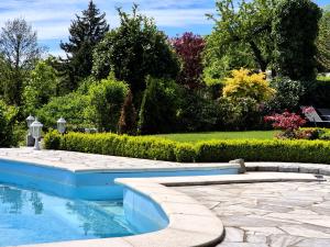 a swimming pool in a garden with a stone patio at Ihre Auszeit am Golfplatz in Meisdorf