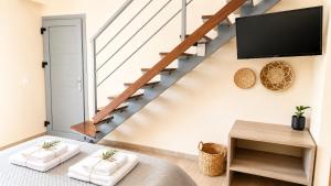 a living room with a staircase with a flat screen tv at Danny Arz Apartments in Iraklitsa