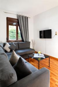 a living room with a couch and a tv at Bright and central apartment in Siátista