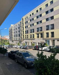 a parking lot with cars parked in front of a building at Aqui é o seu lugar. in Bobadela