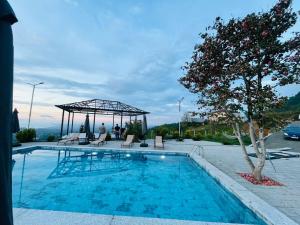 a swimming pool with a gazebo and a tree at Flora-A in Chakvi